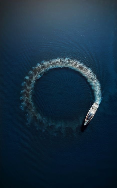 Aerial view of a motorboat creating ripples on open water