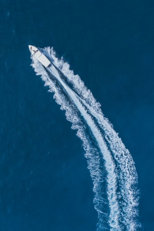 White speedboat cutting through clear turquoise water